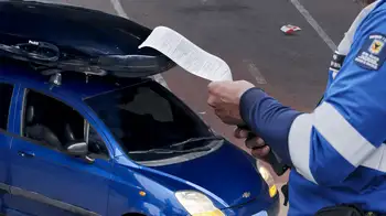 El Chevrolet Spark azul sobre la rampa del puente peatonal de la carrera 68 con calle 26. El conductor del Spark del puente peatonal en Bogotá tiene 43 comparendos: esta es la deuda