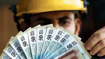 Un obrero muestra unos billetes para ilustrar el salario mínimo en Colombia La tutela con la que pretenden tumbar el aumento del salario mínimo en Colombia