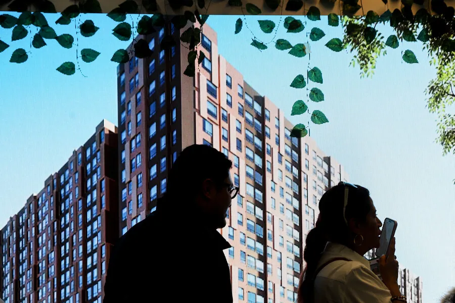 Una pareja está al frente de un edificio para ilustrar la compra de vivienda en Colombia Expertos cuestionan el decreto que desindexa el costo de vivienda del salario mínimo en Colombia